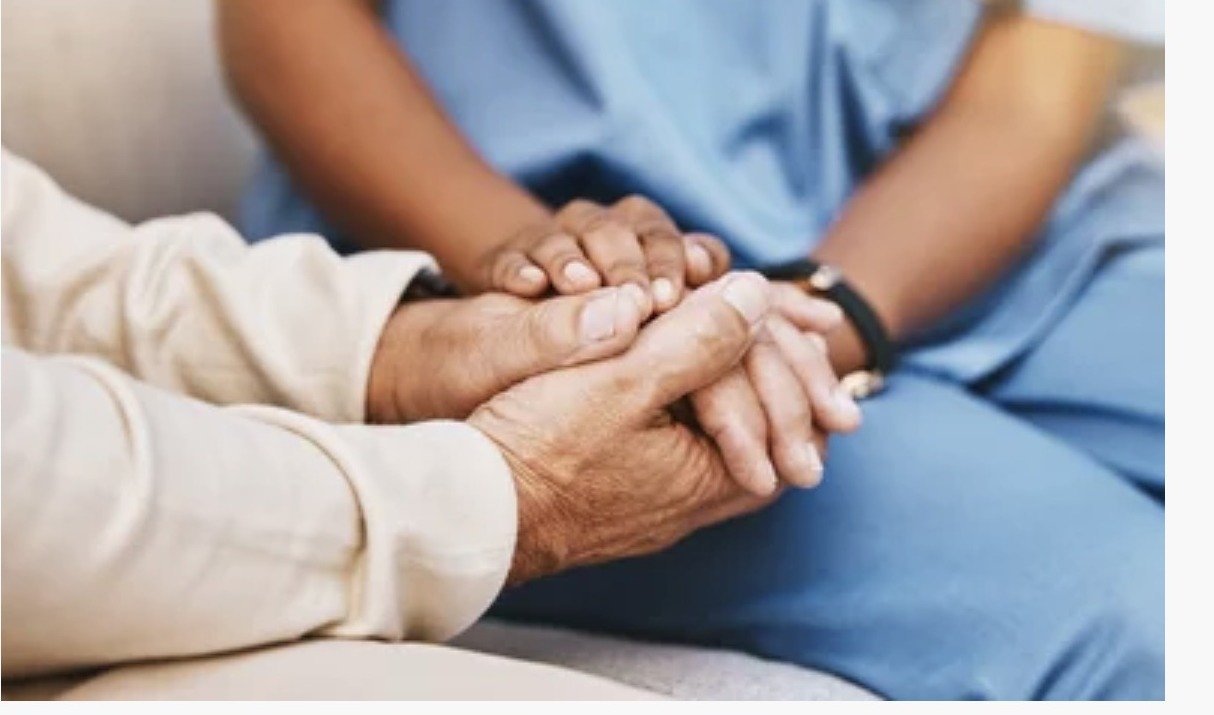 Caregiver holding senior's hand with compassion in Naples